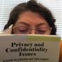 Marisol Moreno Ortiz reads a book called Privacy and Confidentiality Issues