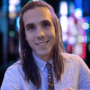 :Librarian Andrew Shaman smiles at the camera with long hair and a tie
