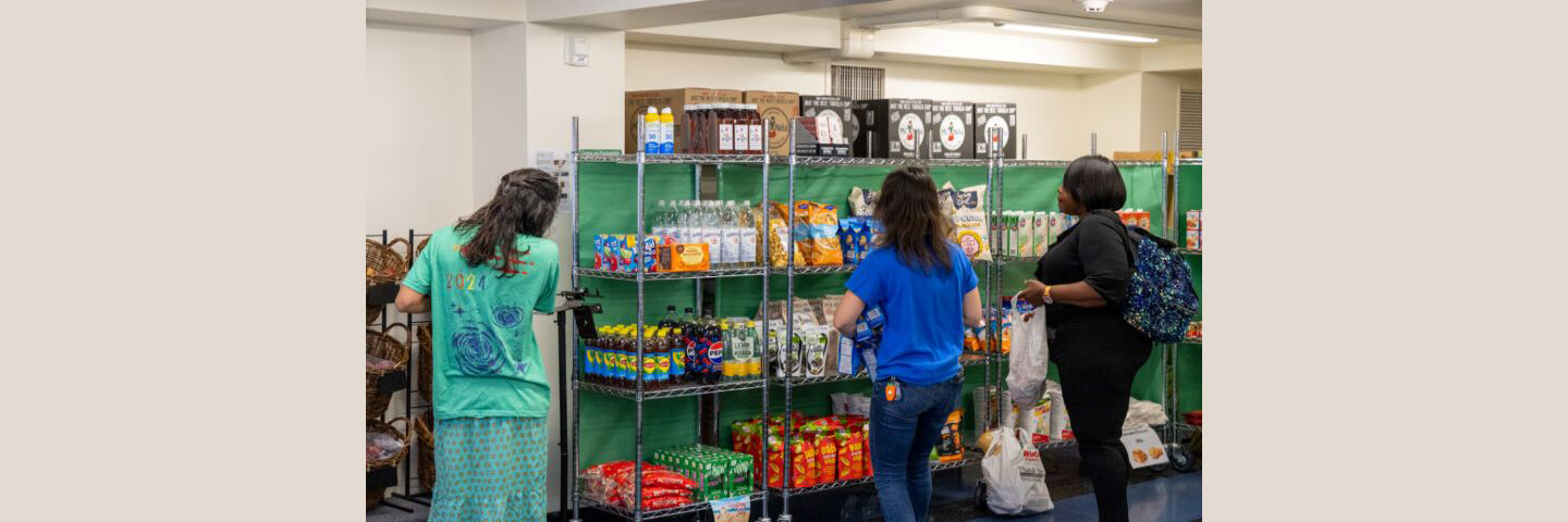 Interior of penguin pantry with three people stocking and shopping the shelves